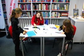 Zdjęcie przedstawia ludzi w bibliotece