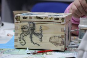 Zdjęcie przedstawia ludzi w bibliotece