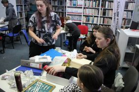 Zdjęcie przedstawia ludzi w bibliotece