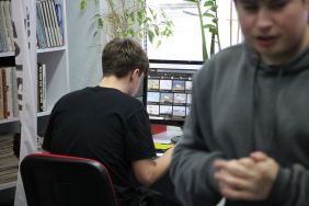 Zdjęcie przedstawia ludzi w bibliotece