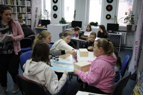 Zdjęcie przedstawia ludzi w bibliotece