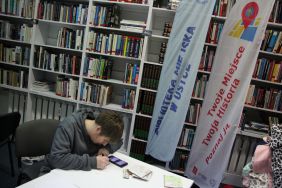 Zdjęcie przedstawia ludzi w bibliotece