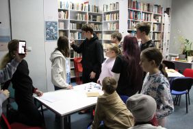 Zdjęcie przedstawia ludzi w bibliotece