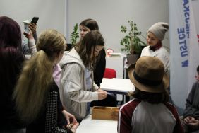 Zdjęcie przedstawia ludzi w bibliotece