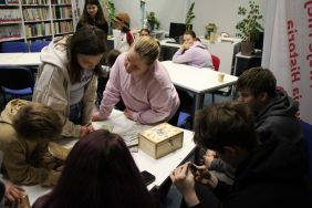 Zdjęcie przedstawia ludzi w bibliotece