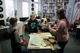 Zdjęcie przedstawia ludzi w bibliotece