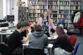 Zdjęcie przedstawia ludzi w bibliotece