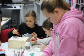 Zdjęcie przedstawia ludzi w bibliotece