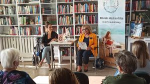 Ludzie w bibliotece podczas spotkania autorskiego