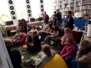 Zdjęcie przedstawia grupę ludzi oglądających bajkę wyświetlaną za pomocą projektora Anka