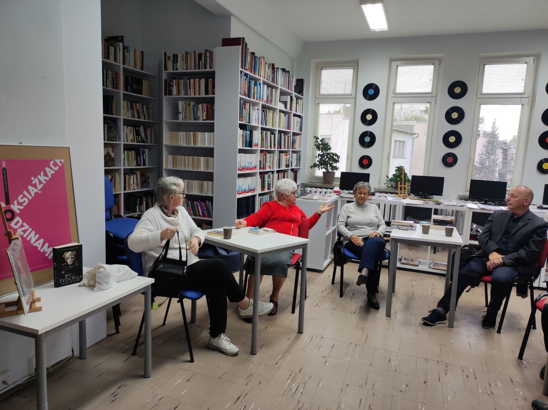 Zdjęcie przedstawia ludzi w bibliotece