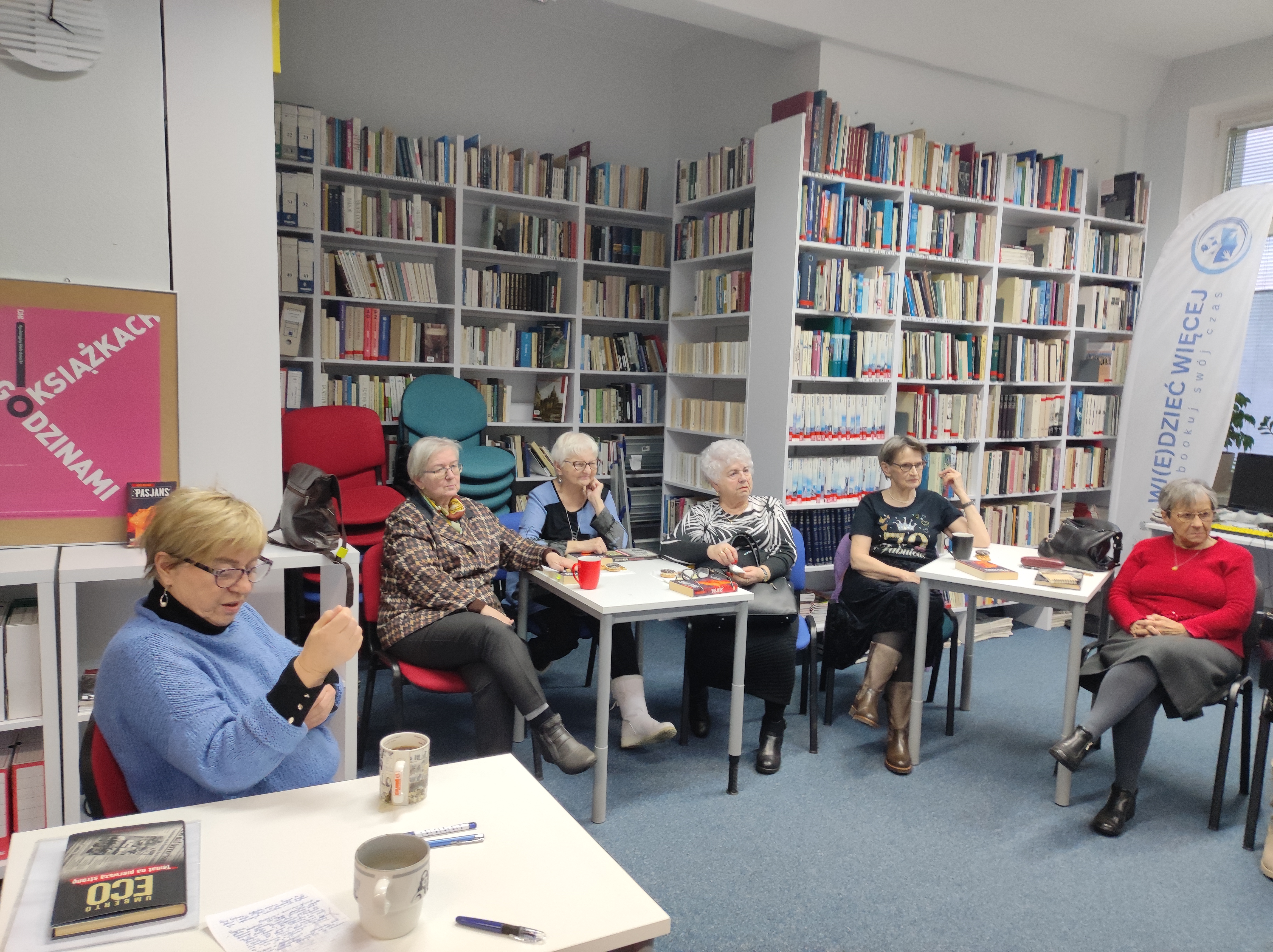 Zdjęcie przedstawia ludzi w bibliotece