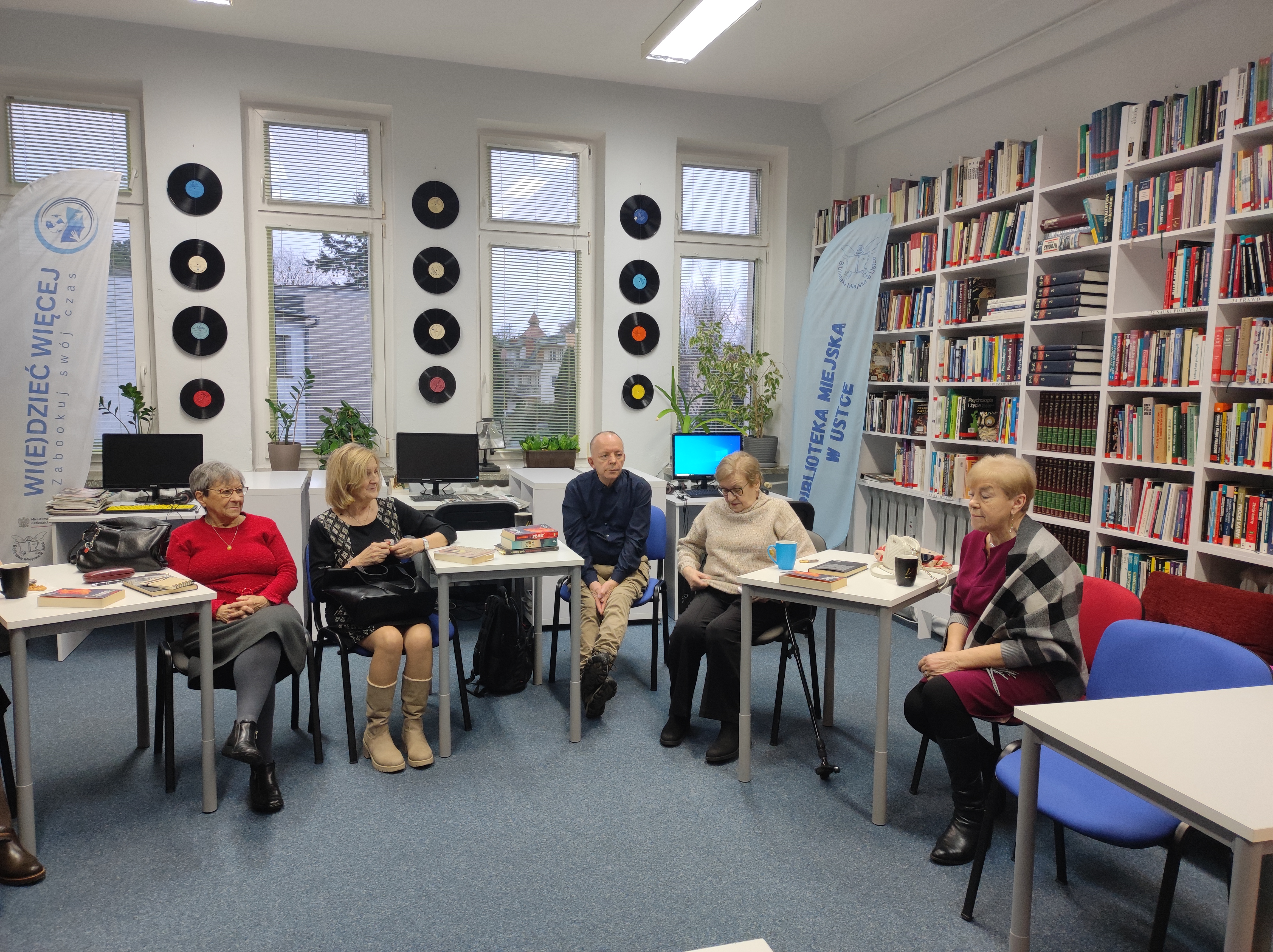 Zdjęcie przedstawia ludzi w bibliotece