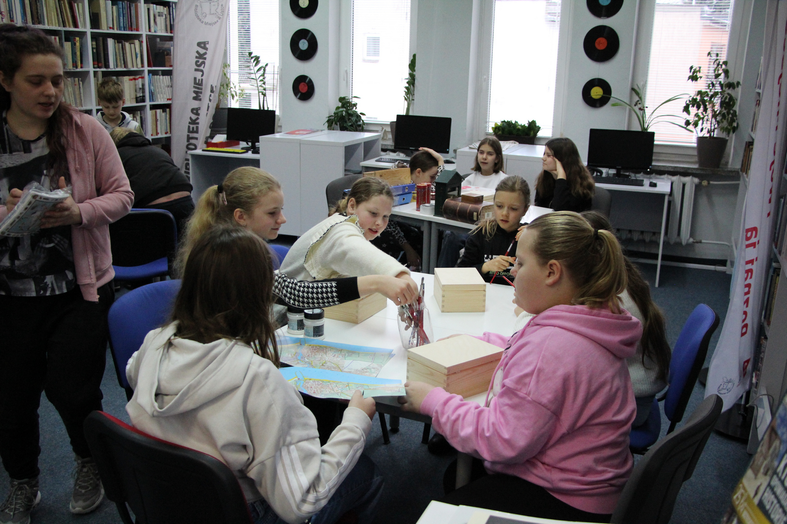 Zdjęcie przedstawia ludzi w bibliotece