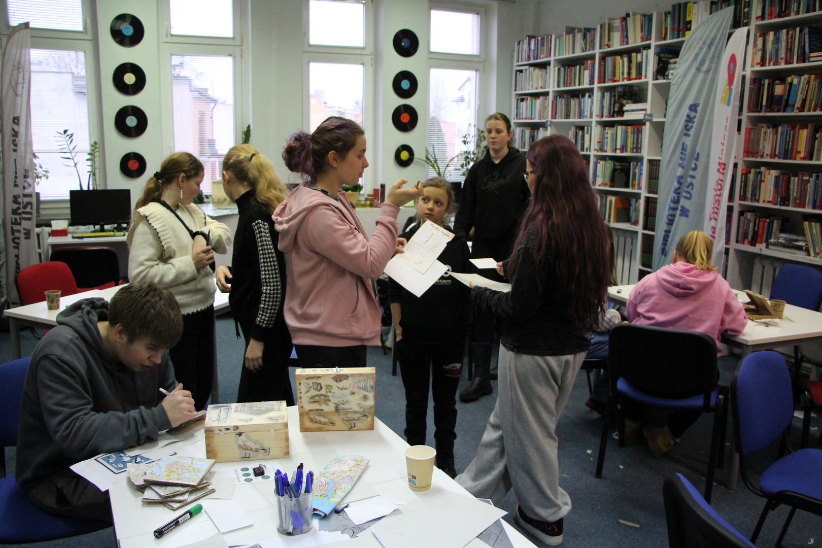Zdjęcie przedstawia ludzi w bibliotece