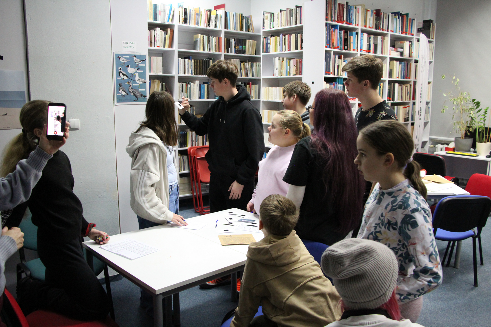 Zdjęcie przedstawia ludzi w bibliotece