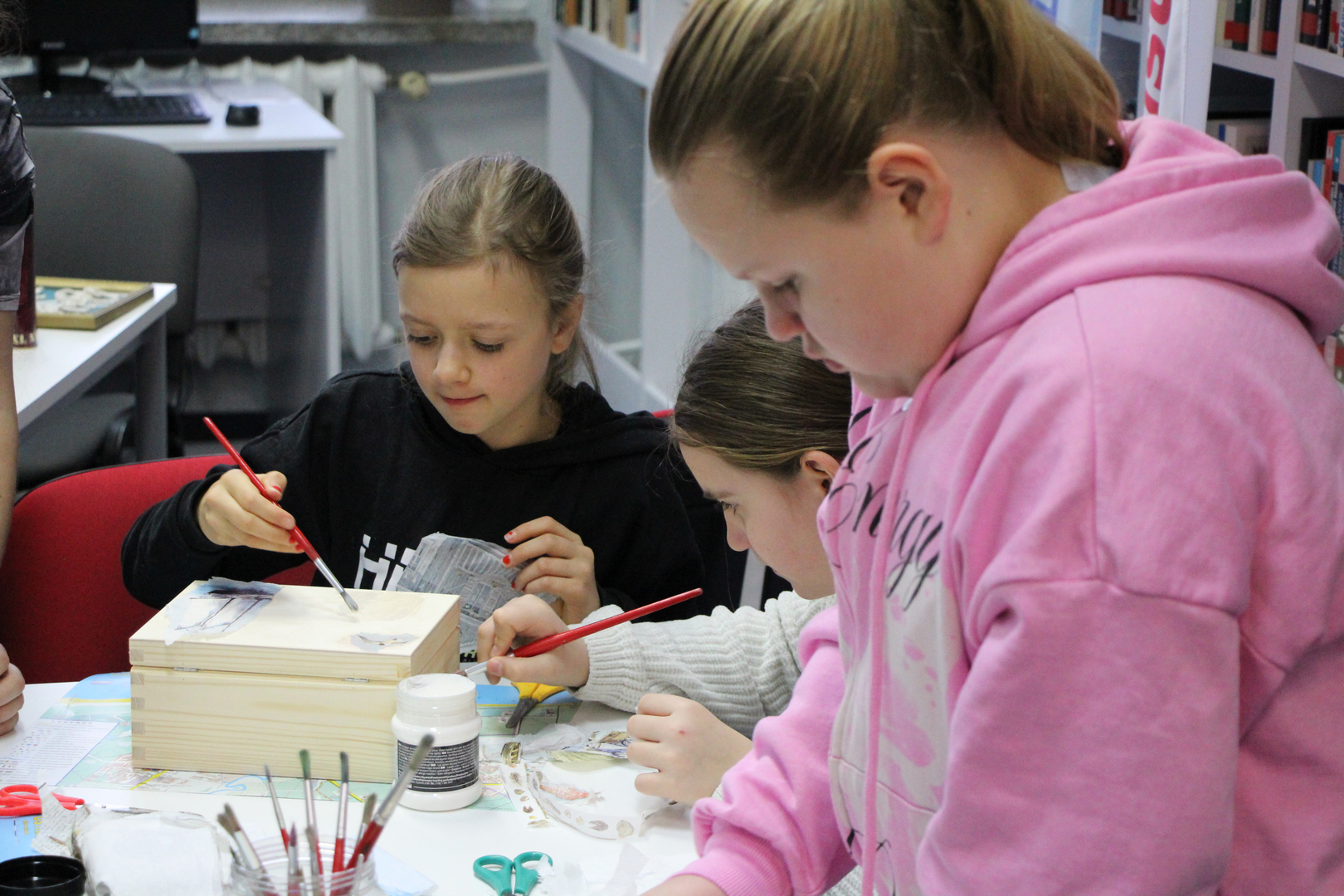 Zdjęcie przedstawia ludzi w bibliotece