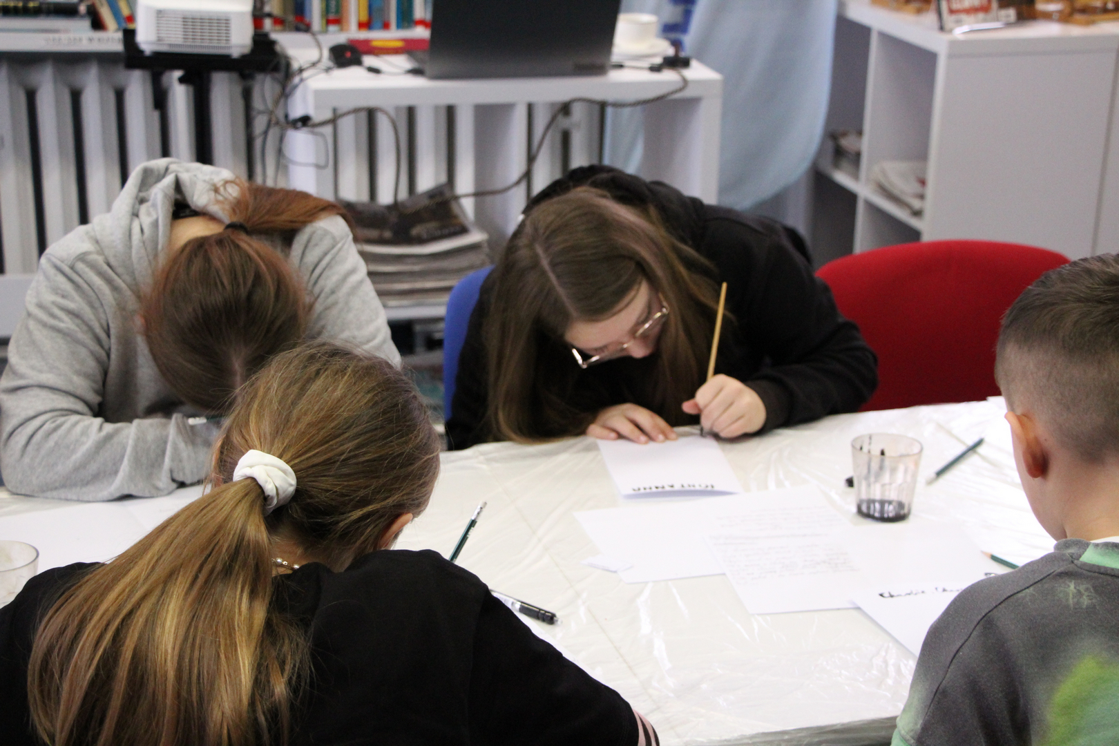 Zdjęcie przedstawia ludzi w bibliotece