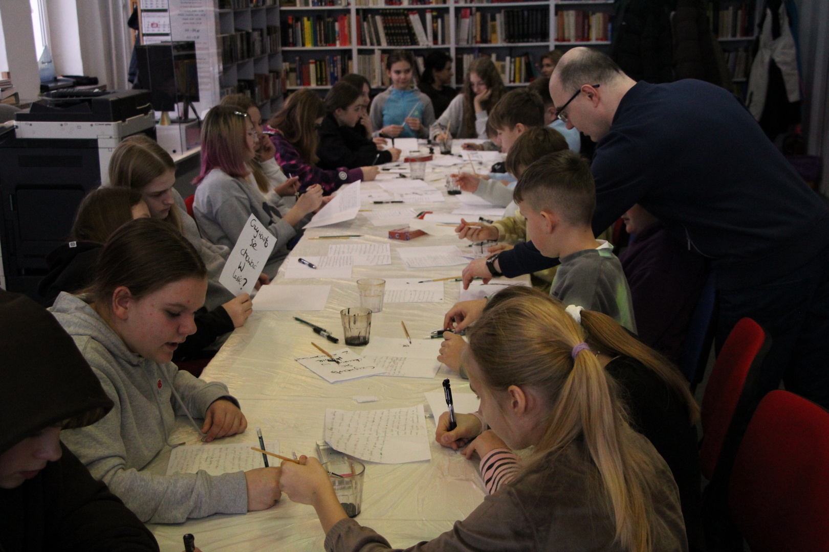 Zdjęcie przedstawia ludzi w bibliotece