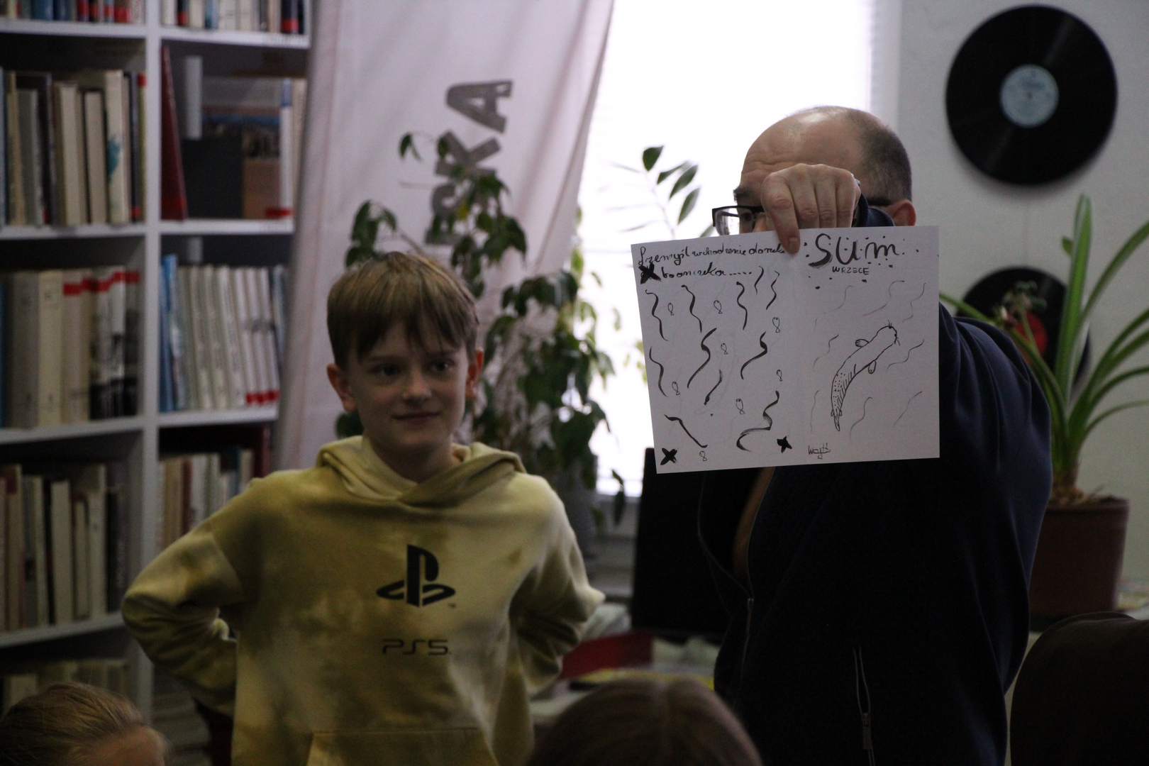 Zdjęcie przedstawia ludzi w bibliotece