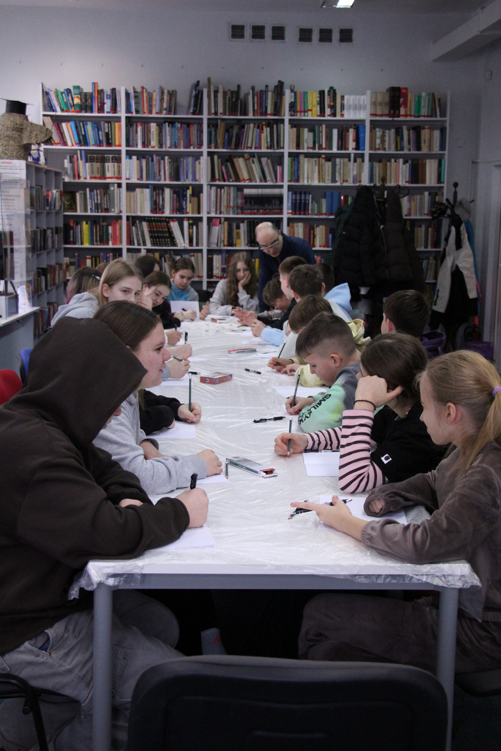 Zdjęcie przedstawia ludzi w bibliotece