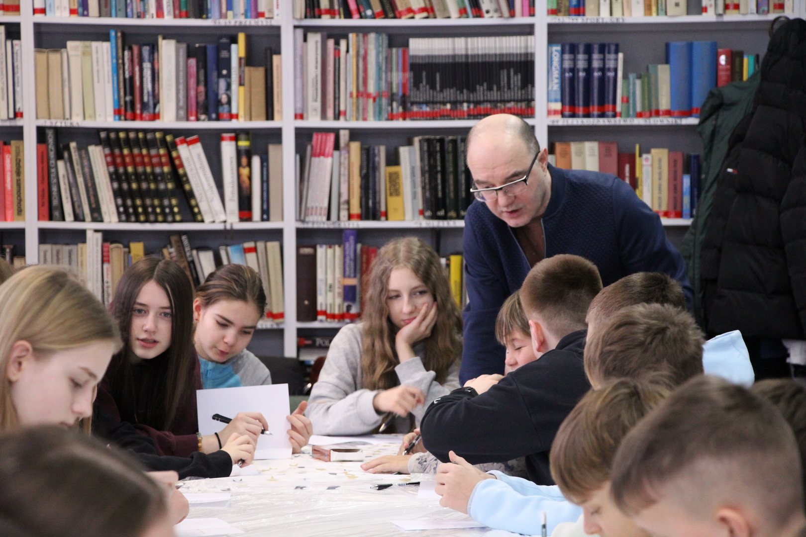 Zdjęcie przedstawia ludzi w bibliotece