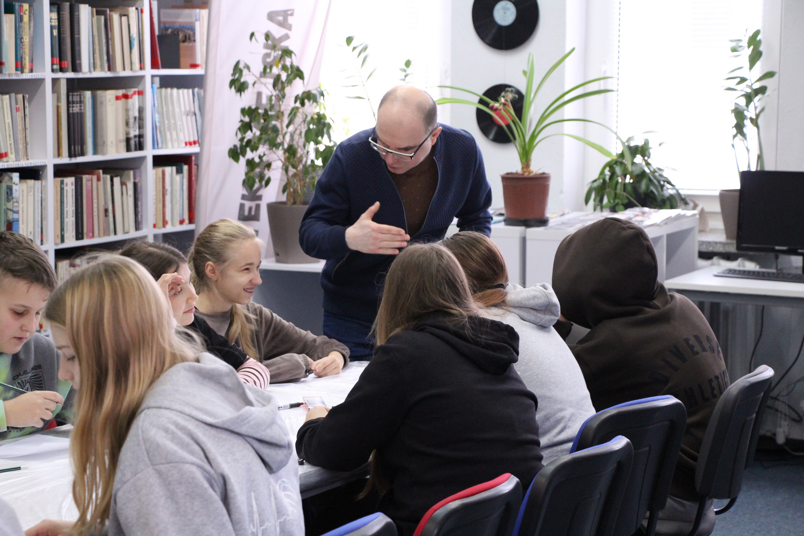 Zdjęcie przedstawia ludzi w bibliotece